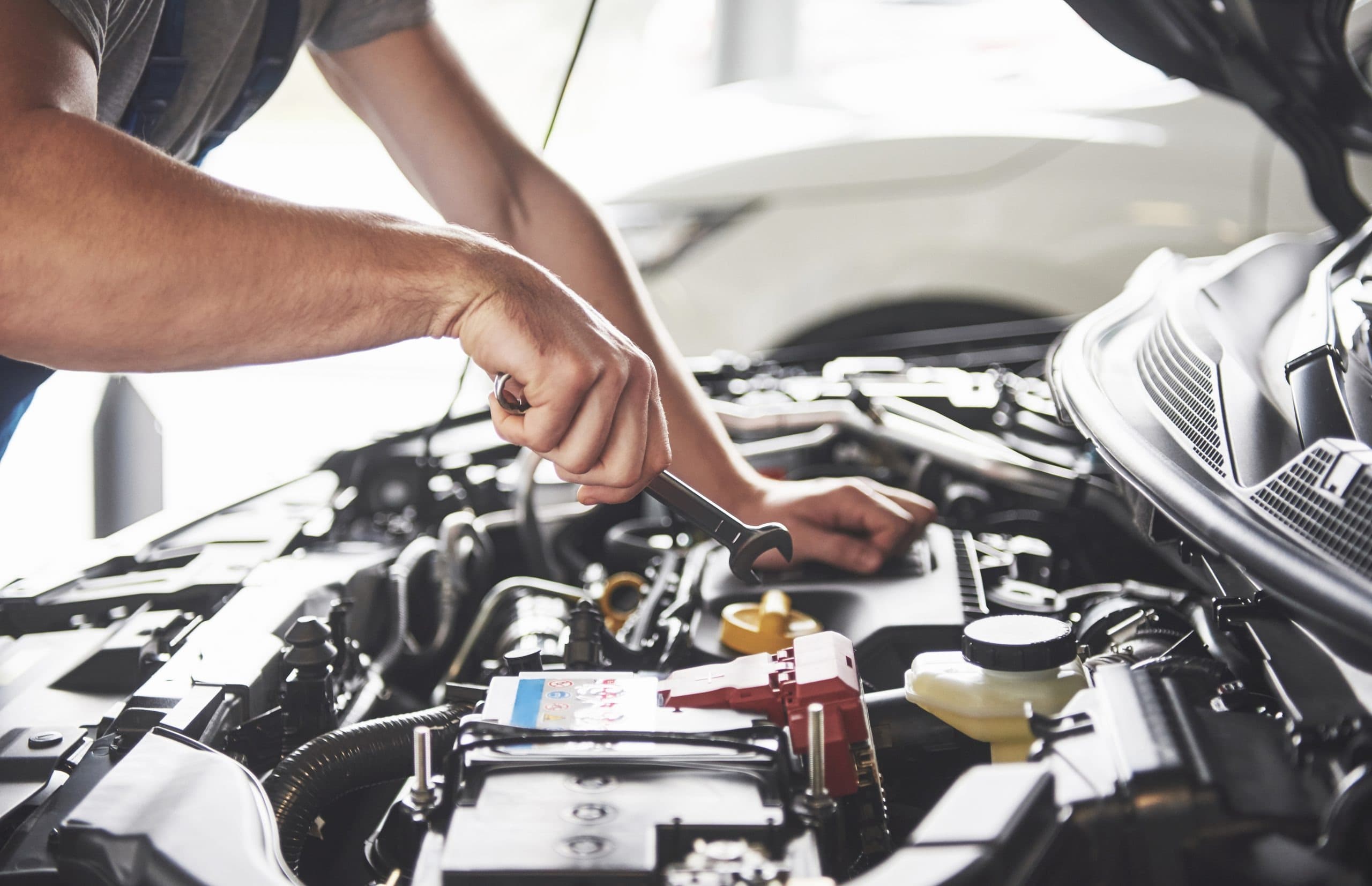 A CarHero mechanic working under the bonnet of a customer's car